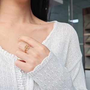 Detailed view of an oval peridot ring set in a golden vintage palace style frame