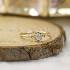 Macro detail of natural aquamarine ring with side purple stones on wooden texture