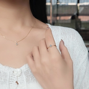 Macro detail of natural aquamarine S925 silver ring and necklace set on female hand