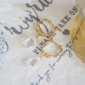Vue détaillée de boucles d'oreilles dorées en cristal avec texture martelée