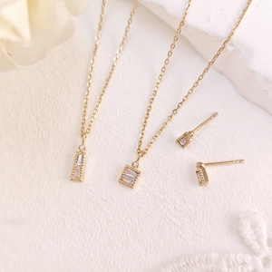 Detailansicht von vergoldetem Schmuckset mit Baguette-Zirkonia und Milgrain-Verzierung