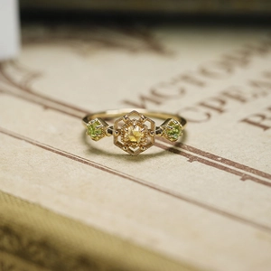 Makroaufnahme des Citrin- und Peridot-Rings im Vintage-Stil auf einer antiken Buchseite