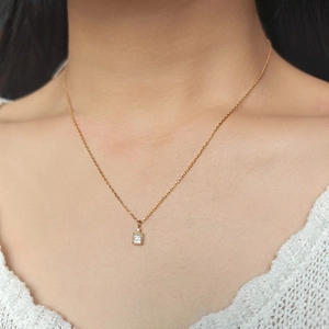 Nahaufnahme der goldenen Kette mit Baguette-Zirkonia-Anhänger im Vintage-Rahmen