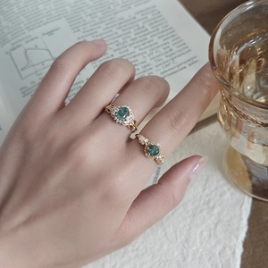 Elegant gold rings with sunflower moss agate stones on vintage book background