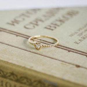 Detailaufnahme eines Vintage-Goldrings mit Blumenmotiv und Weizenähren-Gravur auf der Seite