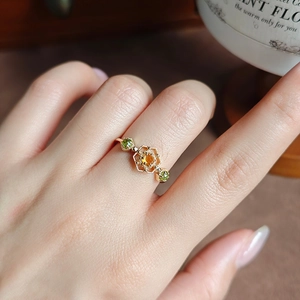 Nahaufnahme von vergoldetem s925-Ring mit orangem Citrin und grünen Olivensteinen