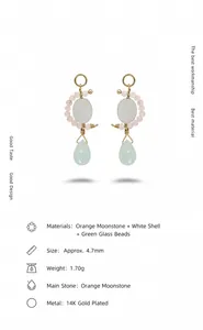 Détail de boucles d'oreilles en perles avec pierre de lune, nacre et goutte de verre