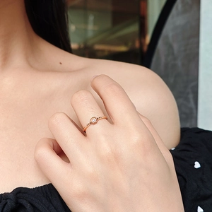 Nahaufnahme eines 14k vergoldeten S925 Silberrosenrings mit Moissanit am Finger eines Modells