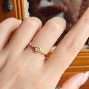 Detail eines s925 Silber 14k vergoldeten Rings mit Moissanit-Blumendesign am Finger