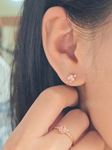 Detail of pink gemstone jewelry set with rose gold twisted band and side accent diamonds
