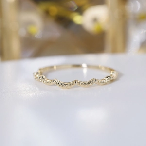 Detailed macro view of gold milgrain wave ring showing delicate beaded texture and finish
