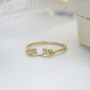Minimalist gold ring featuring two detailed cupid angels on a slim stackable band