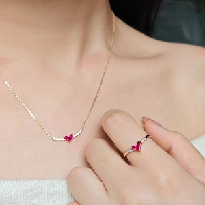 Close-up of heart red gemstone necklace and ring set on model with gold finish