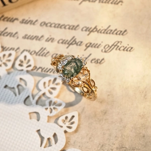 Macro view of vintage moss agate ring with gold filigree and sparkling white zircons