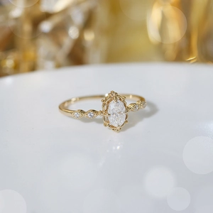 Λεπτομέρεια δαχτυλιδιού με moissanite marquise cut και vintage επιχρυσωμένα σχέδια