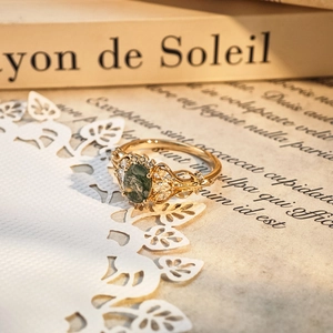 Macro shot of vintage gold S925 moss agate ring with delicate filigree and zircons