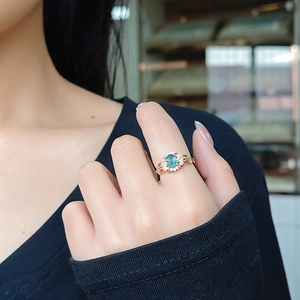 Close-up of moss agate ring in rose gold with vintage filigree and side diamonds