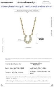 Detailed macro view of U-shaped horseshoe necklace pendant with 14K gold plating and white zircon