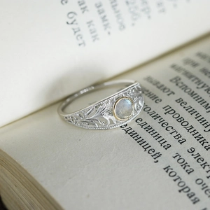 Vintage S925 silver labradorite ring with hollow lace design on an old book
