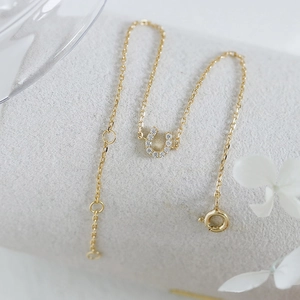 Macro shot of 14k gold plated horseshoe bracelet featuring pave-set cubic zirconia stones