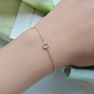 Close-up of a delicate U-shaped horseshoe bracelet with pavé cubic zirconia on the wrist