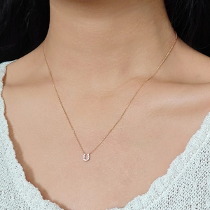U-shaped horseshoe pendant necklace in 14k gold plated silver worn on a woman neck
