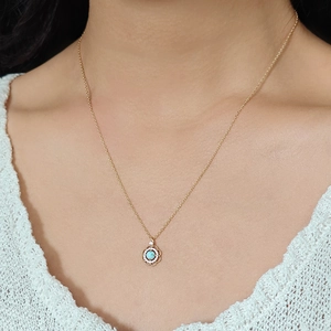 Gros plan du collier fleur évidée avec pierre de larimar bleue et zircons blancs brillants