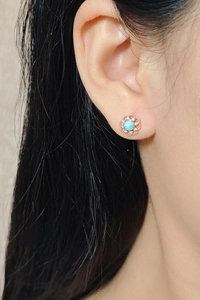 Gros plan de boucles d'oreilles fleur évidée avec pierre Larimar bleue et zircons blancs