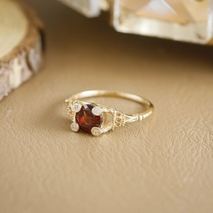 Detailopname van een vintage vergulde S925 zilveren ring met granaat en fijne gravures