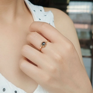 Close-up of a vintage gold ring with an oval dark stone and intricate filigree details