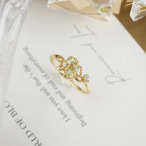 Dettaglio dell'anello a quadrifoglio in oro con peridoti verdi e zirconi bianchi