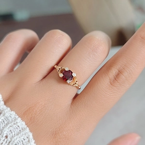 Detail van vintage S925 vergulde ring met rode granaat en verfijnde bloemmotieven