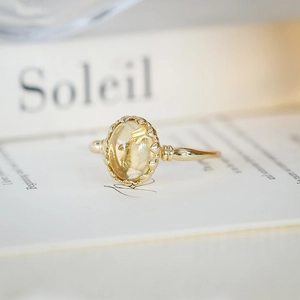 Macro detail of vintage gold ring with oval yellow gemstone and delicate beaded edge