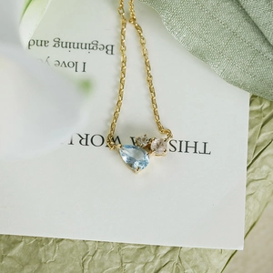 Macro detail of S925 gold plated necklace with blue topaz and multi-color gems