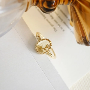 Macro view of gold S925 silver ring featuring a yellow crystal with internal flower detail