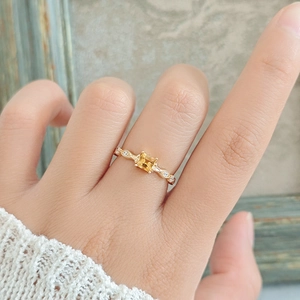 Detailed view of square yellow citrine ring with vintage hollow pattern on gold band