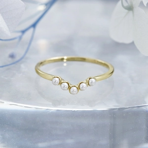Détail macro de la bague en argent S925 plaqué or en V avec cinq perles blanches rondes