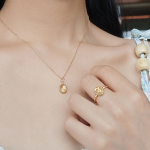 Detail of vintage S925 gilded silver necklace and ring with amber yellow crystal