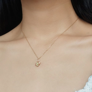 Primo piano della collana a quadrifoglio in oro con gemme verdi sul collo