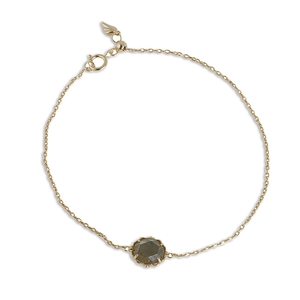 Elegante pulsera de oro con gema de cuarzo ahumado y dije de pluma sobre fondo blanco
