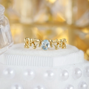 Macro detail of S925 silver lace ring with oval light blue topaz and gold hollow engraving