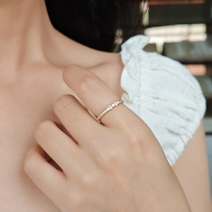 Détail d'une bague minimaliste en argent S925 plaqué or avec cinq petits moissanites