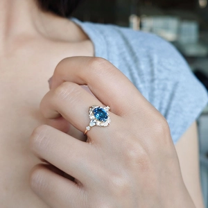 Close-up of a London Blue Topaz ring in rose gold with vintage hollowed design