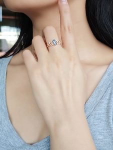 Detail of 14K gold ring featuring London blue topaz and crisscross diamond band