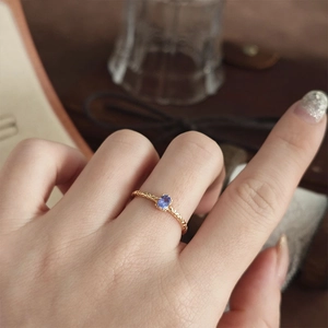 Dettaglio anello in argento s925 placcato oro con fascia intrecciata e tanzanite
