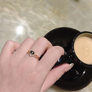 Close-up of S925 silver rings with blue sandstone and zirconia on a hand holding coffee