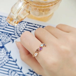 Multicolor natural gemstone ring with rose gold plating on hand in lifestyle setting