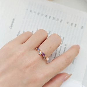 Detailed view of gold ring featuring triangular lab-grown gemstones worn on hand