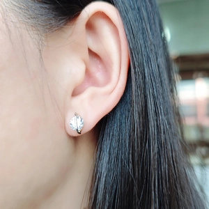 Gros plan d'une boucle d'oreille S925 en argent avec pierre ronde et barre géométrique