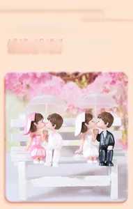 Detail view of miniature PVC wedding couple figurines with bench and umbrella decor